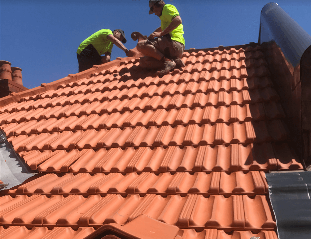 A terracotta roof in the process of restoration with visible areas of repair work.